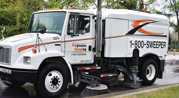 Street Sweeping Truck Sweeping Along Road Curb